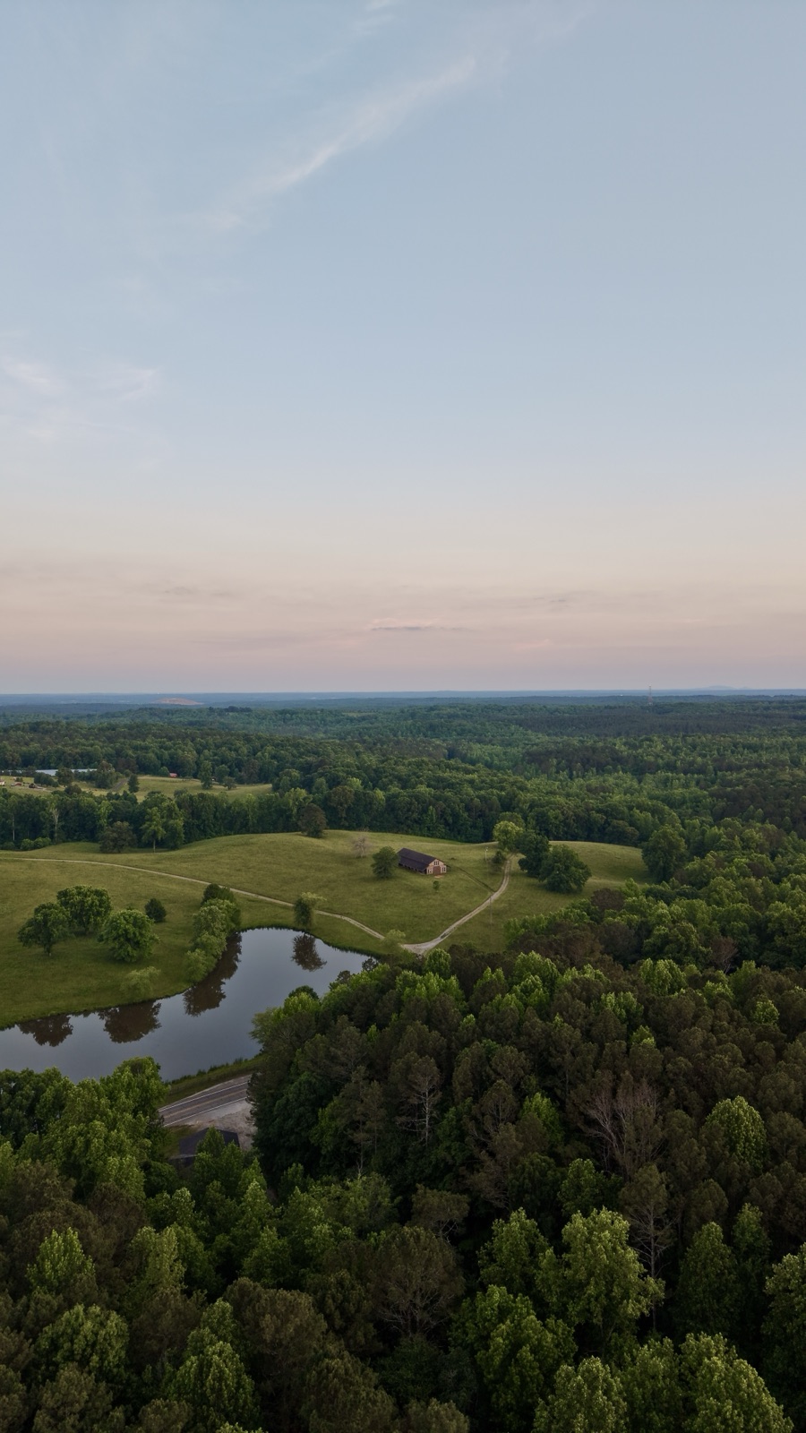 Twilight over farmland with pond